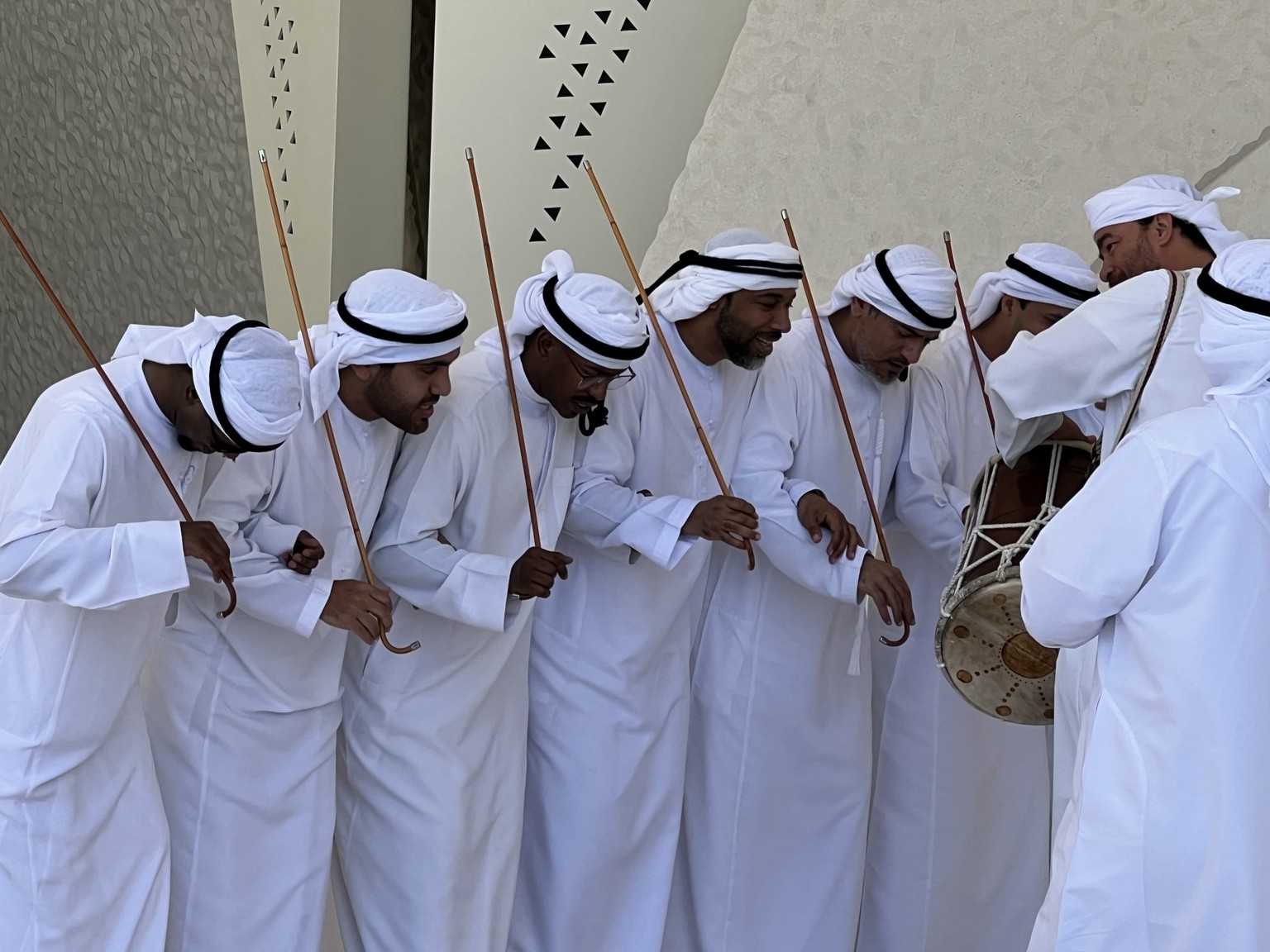 Al Ahla performers in traditional Emirati dress with sticks and drums